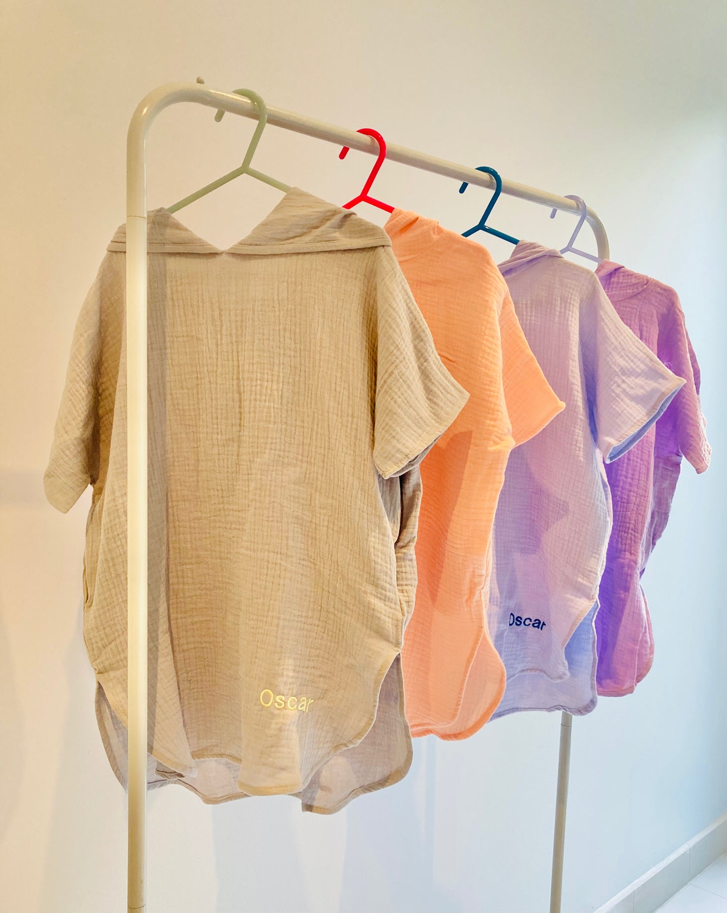 Muslin ponchos on a rack, colours, Grey, Peach, Blue and Purple.