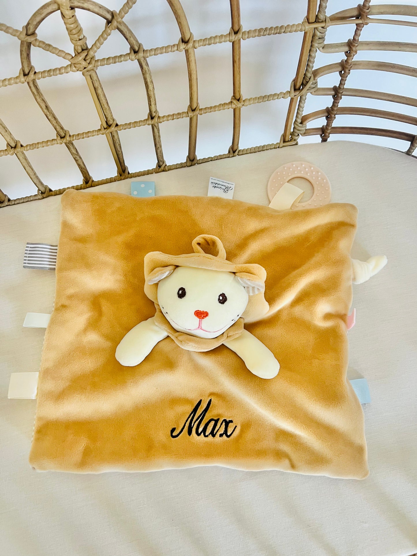 Light brown lion baby comforter personalised with an embroidered name Max in black thread.