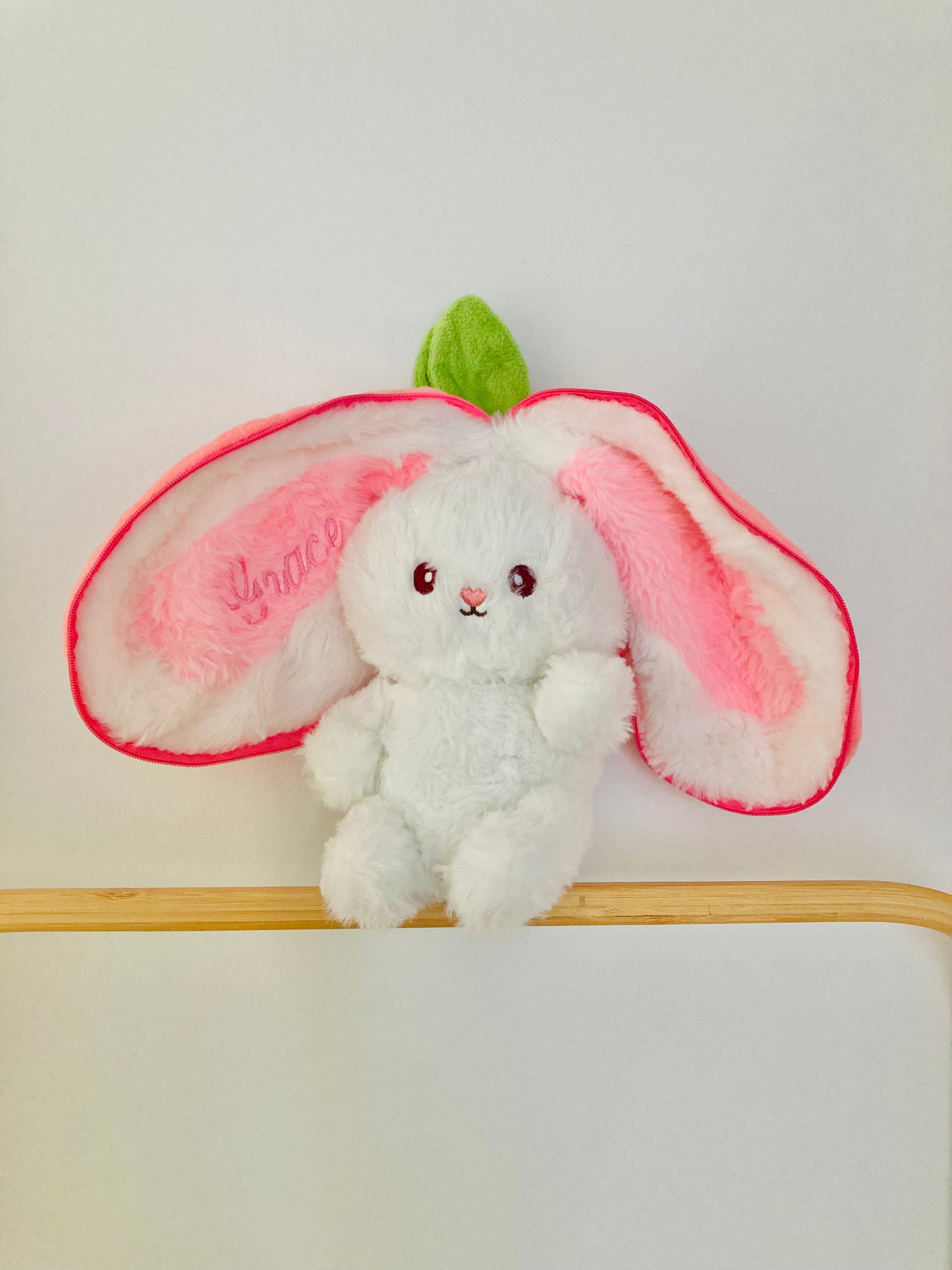 A plush white bunny with pink strawberry ears, embroidered with name Grace. 