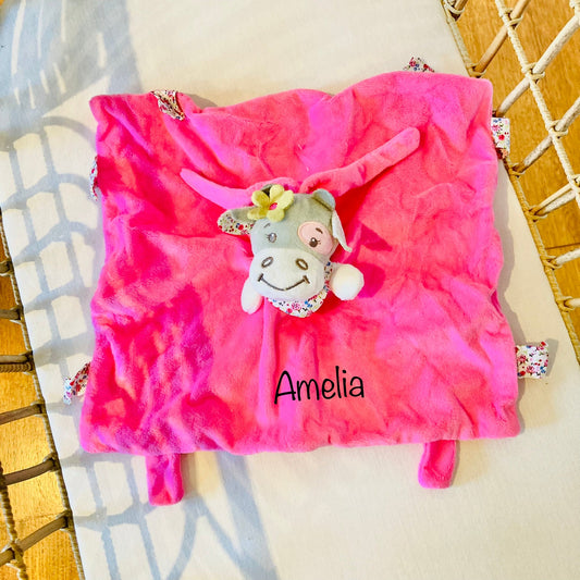 A pink baby comforter with a donkey design, personalized with the name 'Amelia' embroidered on it.